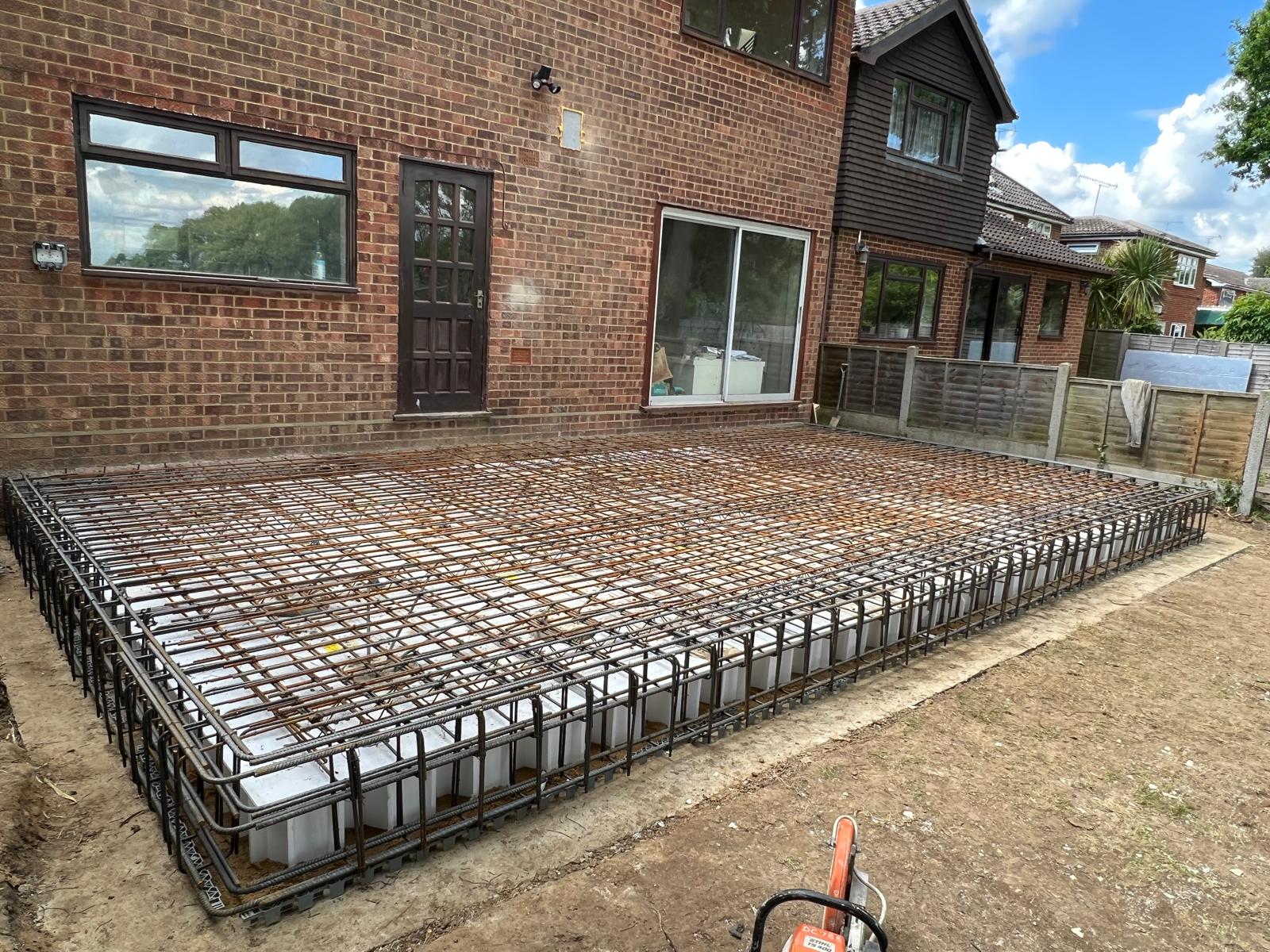 Piled raft foundation with reinforcement and void formers